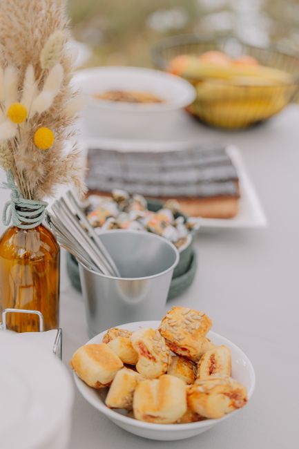 Elegant table setting outdoors with appetizers and dried floral arrangement for a casual gathering.
