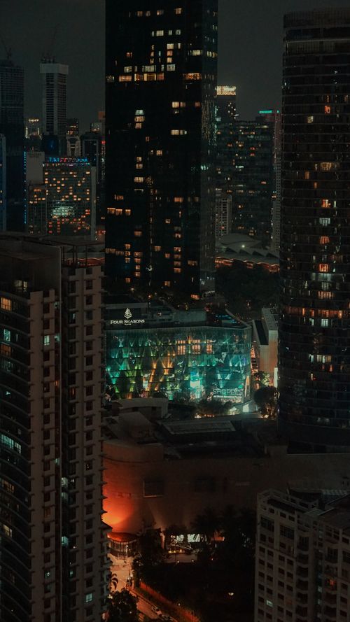 Free A vibrant aerial view of Kuala Lumpur's cityscape at night, featuring modern architecture and luminous city lights. Stock Photo