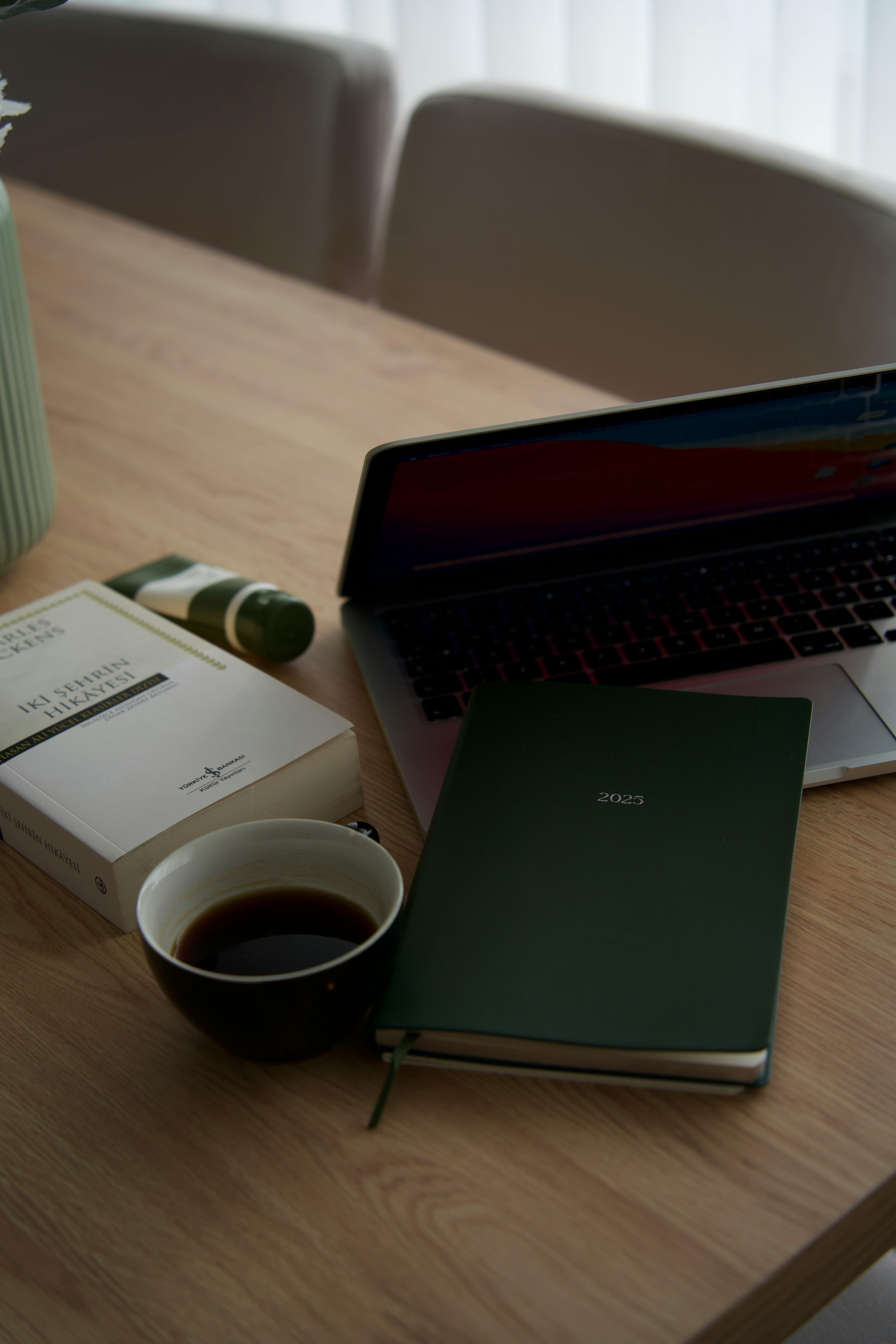 Kostnadsfria En avslappnad arbetsplats med en bärbar dator, kaffe och en grön 2022-dagbok. Stock foto