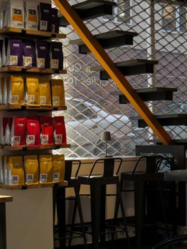 Cozy modern coffee shop interior featuring packaged coffee and sleek black stools.