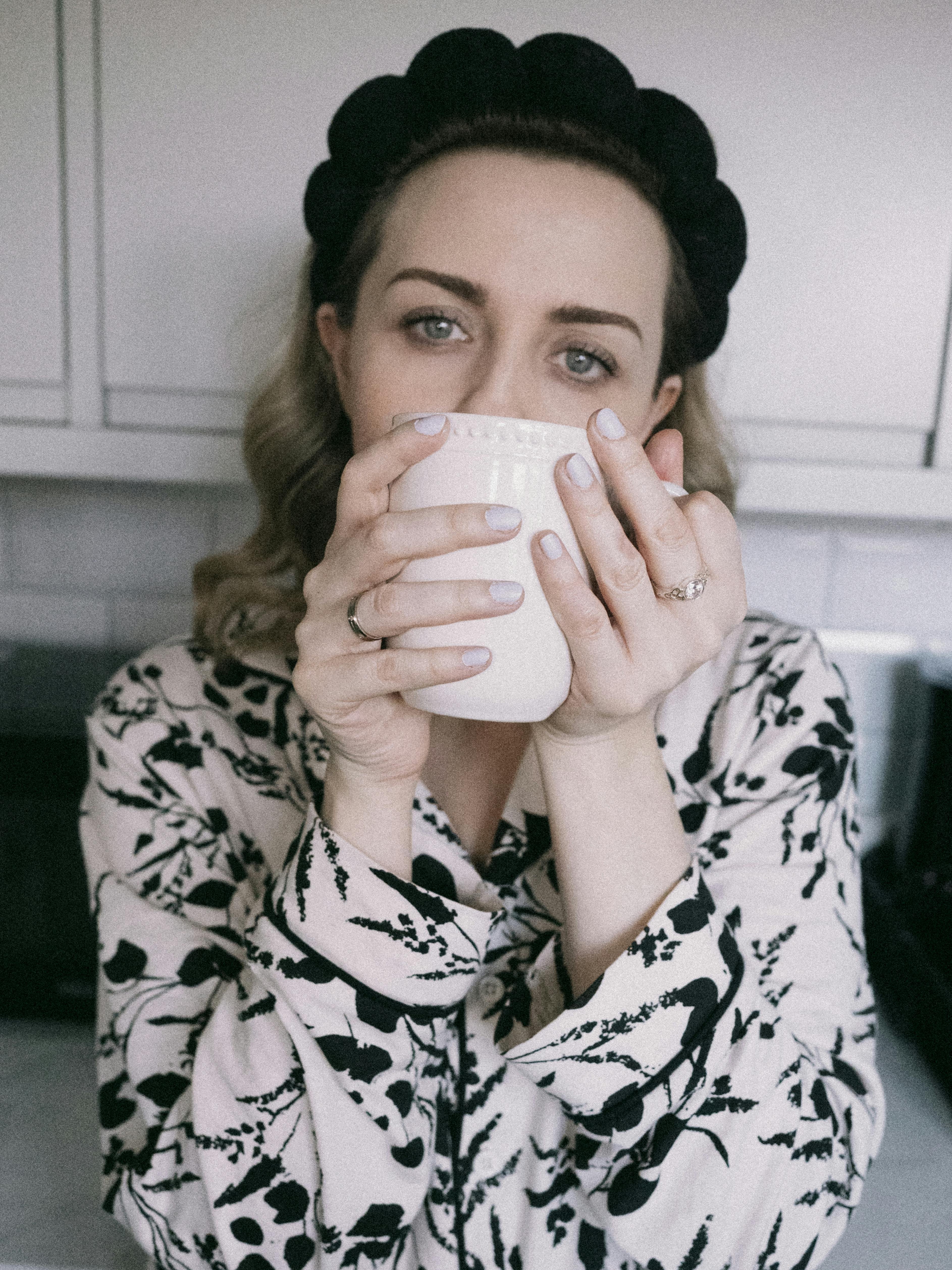 Woman enjoying a warm morning drink in pajamas, creating a cozy and comforting atmosphere.