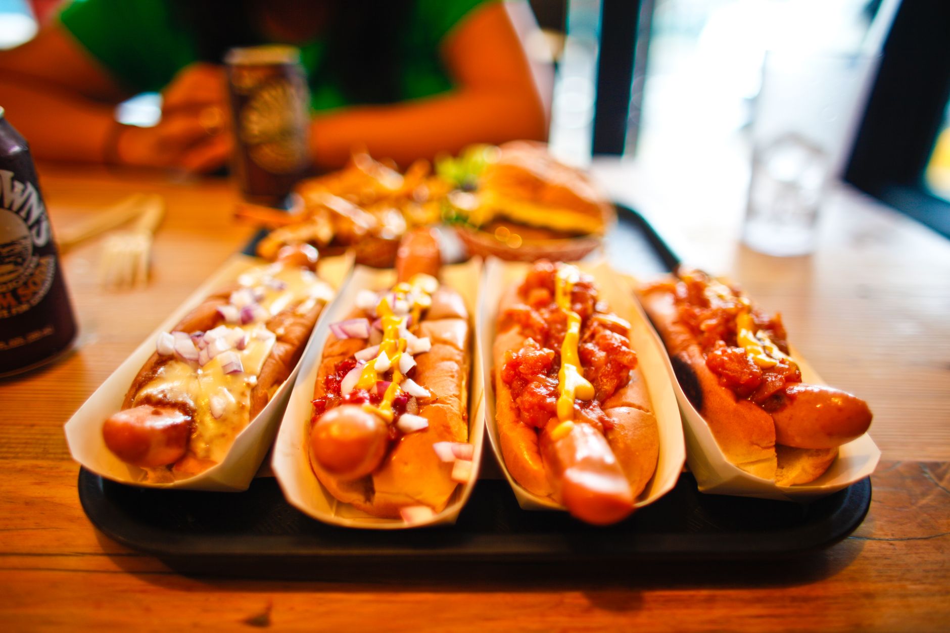 two Detroit-style coney dogs on a white paper tray, piled with beanless beef chili, yellow mustard a