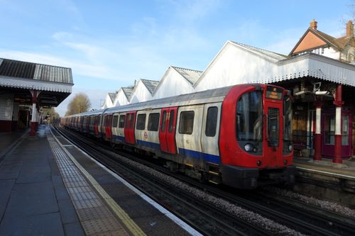Free Red and white train at a historic British train station on a clear day. Stock Photo