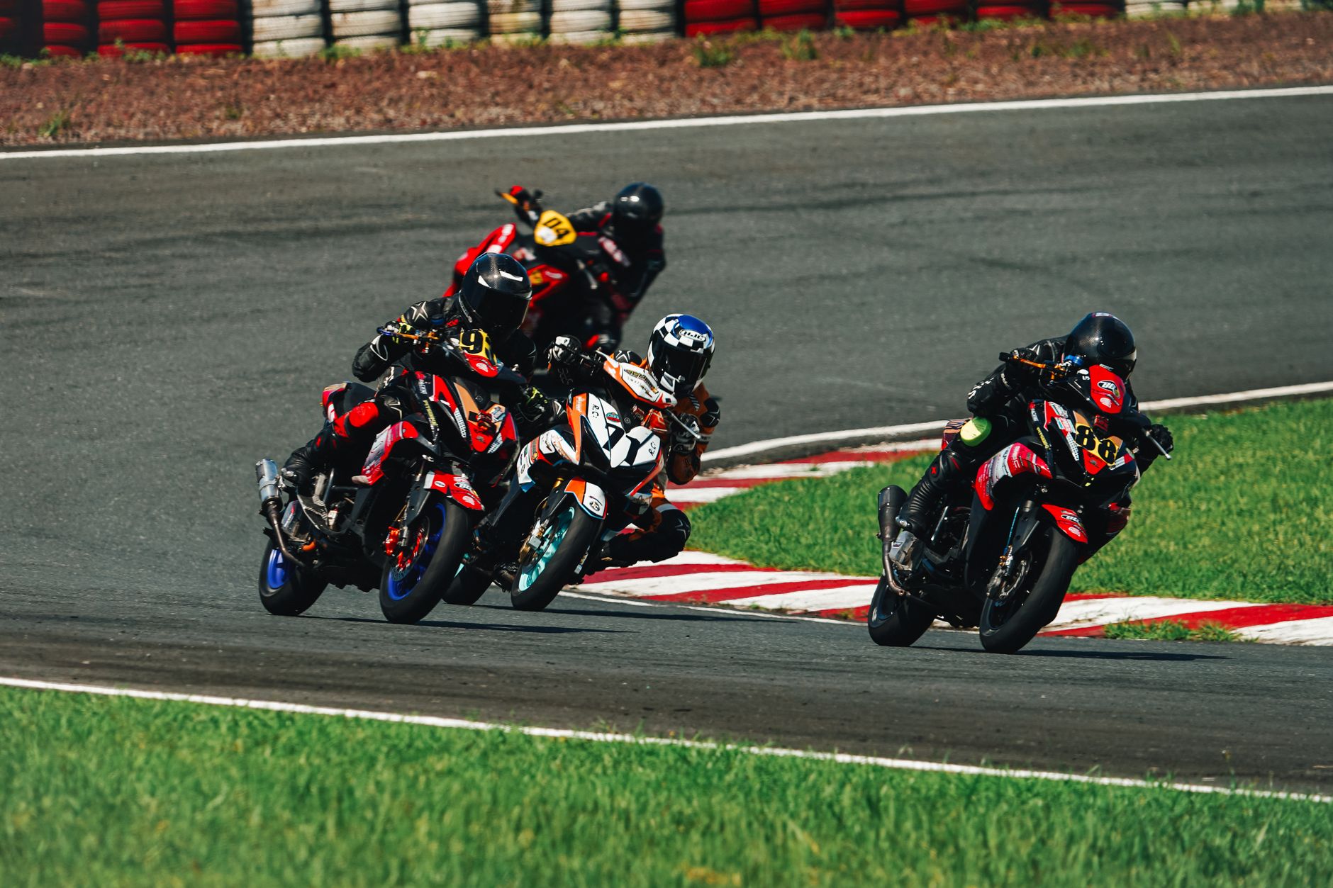 Four motorcyclists racing competitively on a track in Rosario, Philippines.
