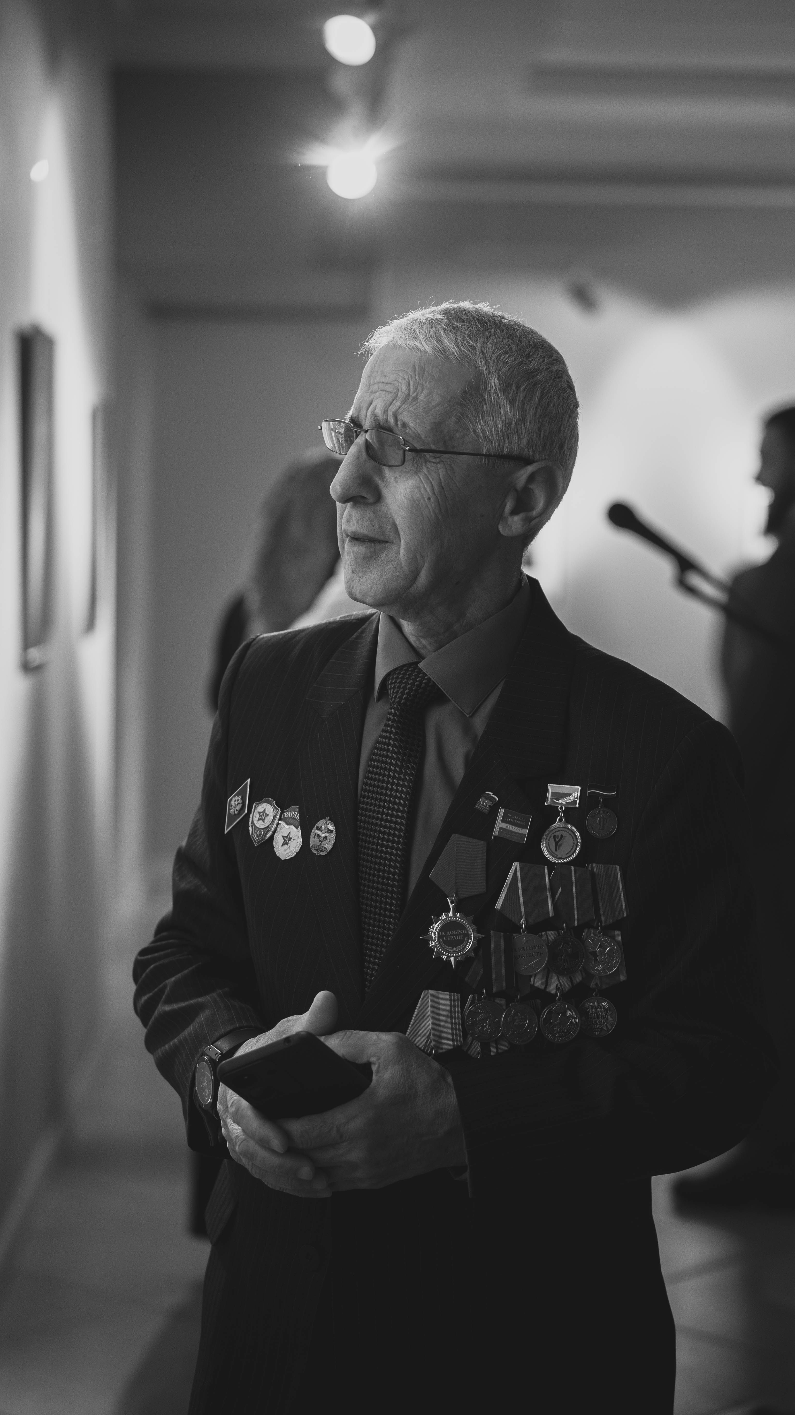 Senior veteran with medals experienced in a gallery setting.