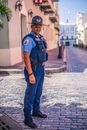 警察身穿制服，站在鹅卵石街道上，确保公共安全