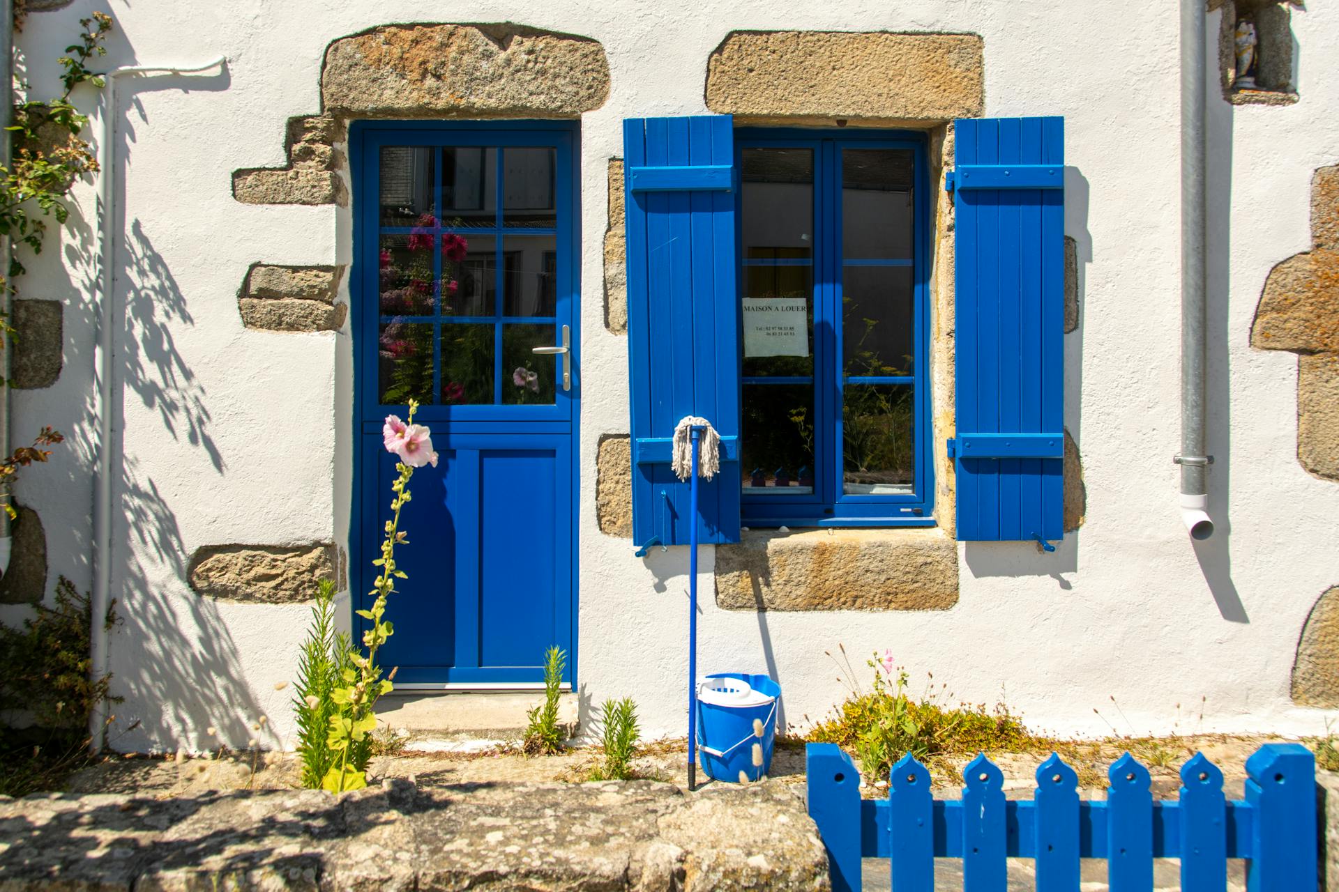 Picturesque facade with blue door and shutters in Hoëdic, Brittany.