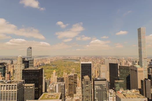 在多云的天空下，一幅俯瞰纽约市天际线的鸟瞰图令人惊叹，远处是中央公园