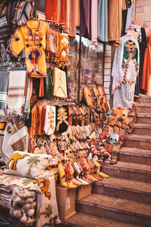 Free Vibrant display of traditional Moroccan garments and shoes in Agadir market. Stock Photo