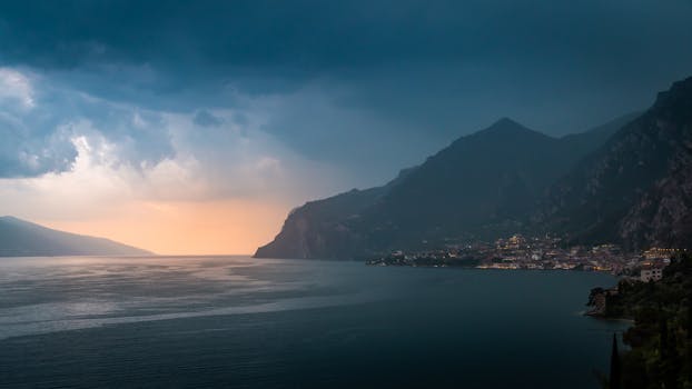 Captivating sunset scene with dramatic clouds over rugged coastline and serene ocean.