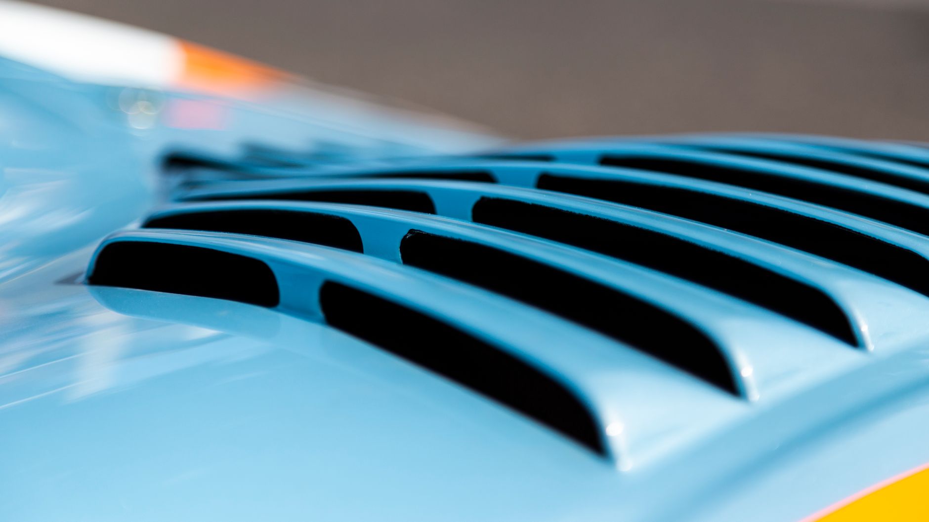 Detailed view of blue car air vents with sunlight reflection.