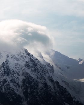 Captivating view of Mont Blanc with clouds at golden hour in Chamonix, France.
