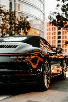 A luxury black sports car parked outdoors in a modern urban environment. Stylish and sleek.