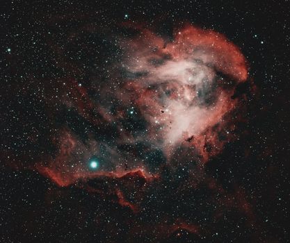 Captivating image of a red nebula amidst a starry sky, illuminating the cosmos.
