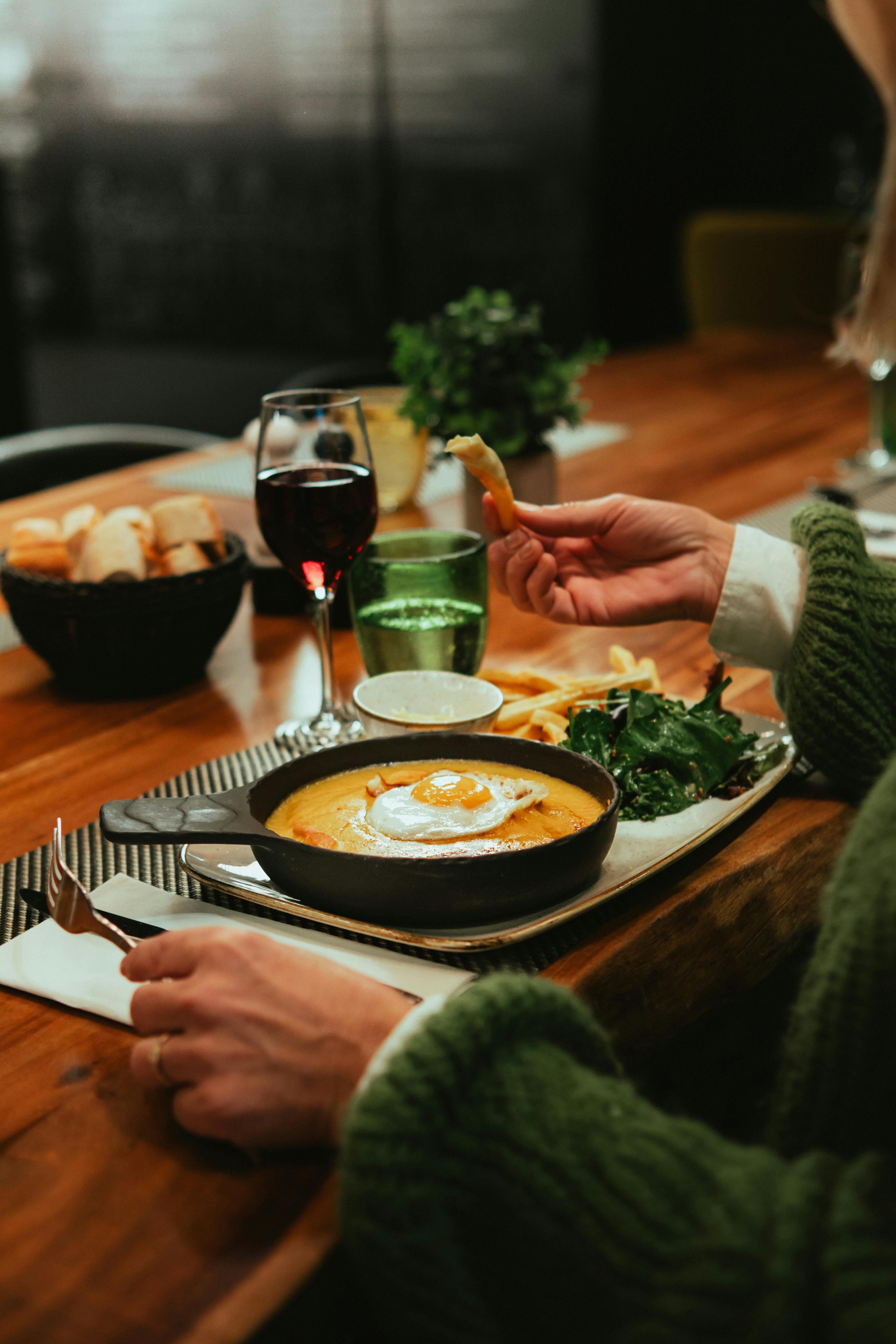 A delightful meal featuring cheese, wine, fries, and salad in a cozy French setting.