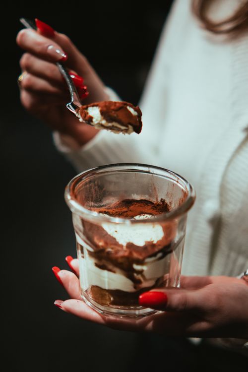 Free Close-up of hands holding a delicious tiramisu dessert in Arras, France. Stock Photo