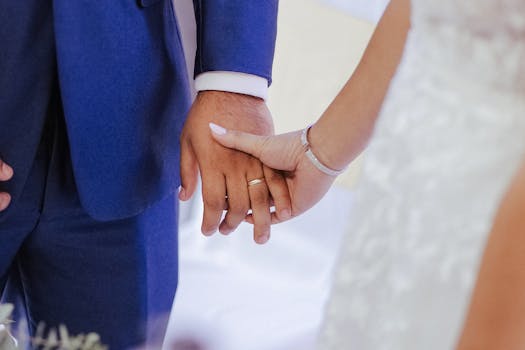 A close-up of bride and groom holding hands, symbolizing love and union at their wedding.