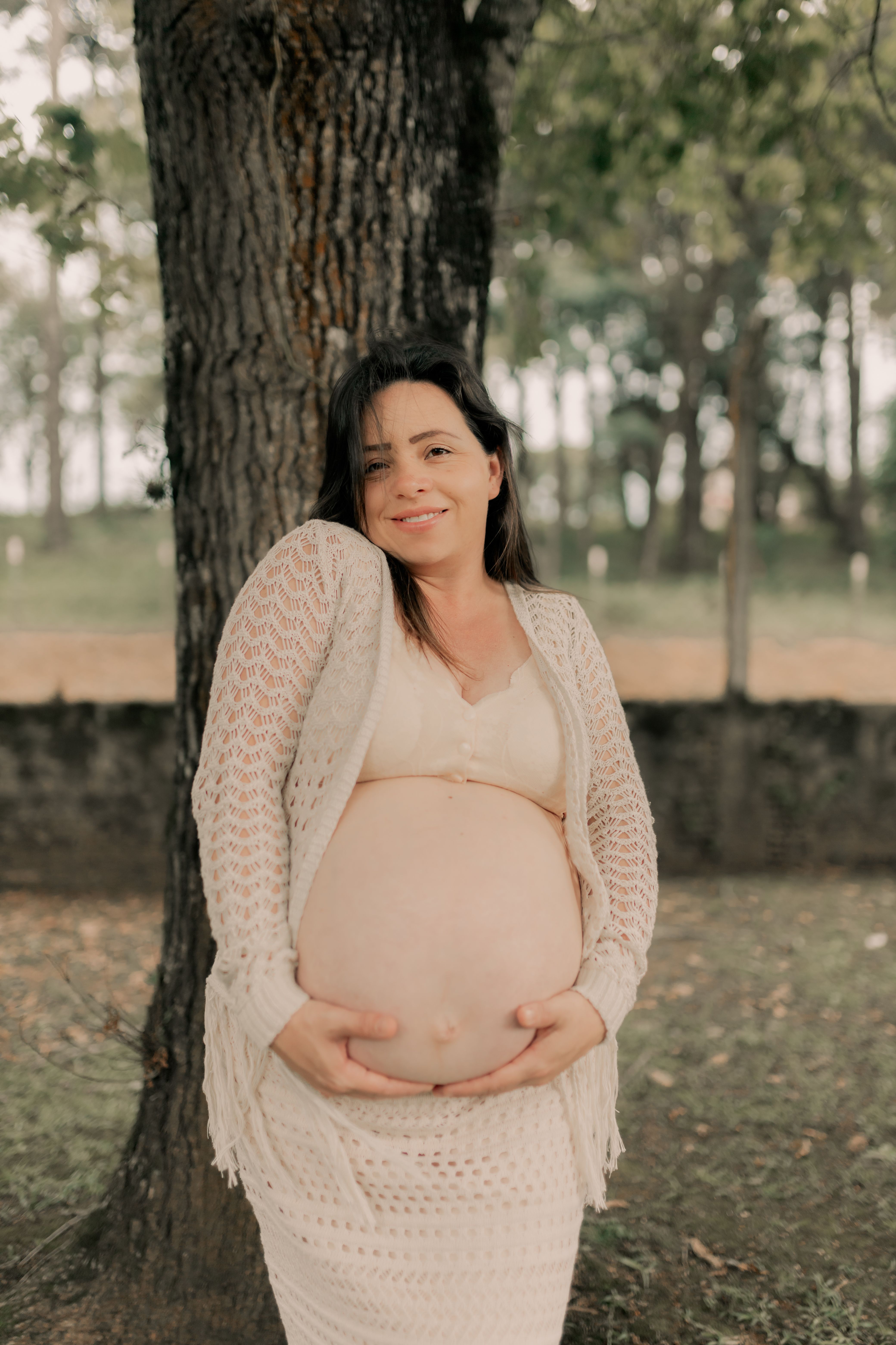 Pregnant Woman Posing Outdoors Under a Tree · Free Stock Photo