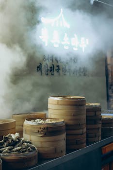 Discover steaming Korean dumplings in Seoul's vibrant night market, captured in atmospheric lighting.