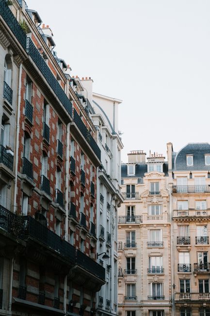 Classic Parisian apartment buildings with early morning light and clear sky.