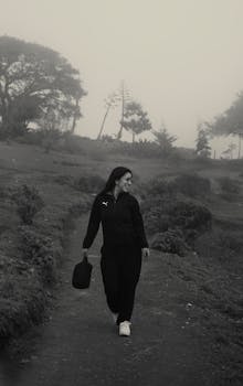 Black and white photo of a woman walking outdoors, exuding a sense of peace and contentment.
