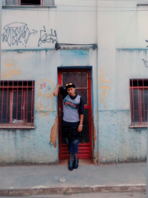 Free A person poses with unique fashion against a graffiti-covered wall in Minas Gerais, Brazil. Stock Photo