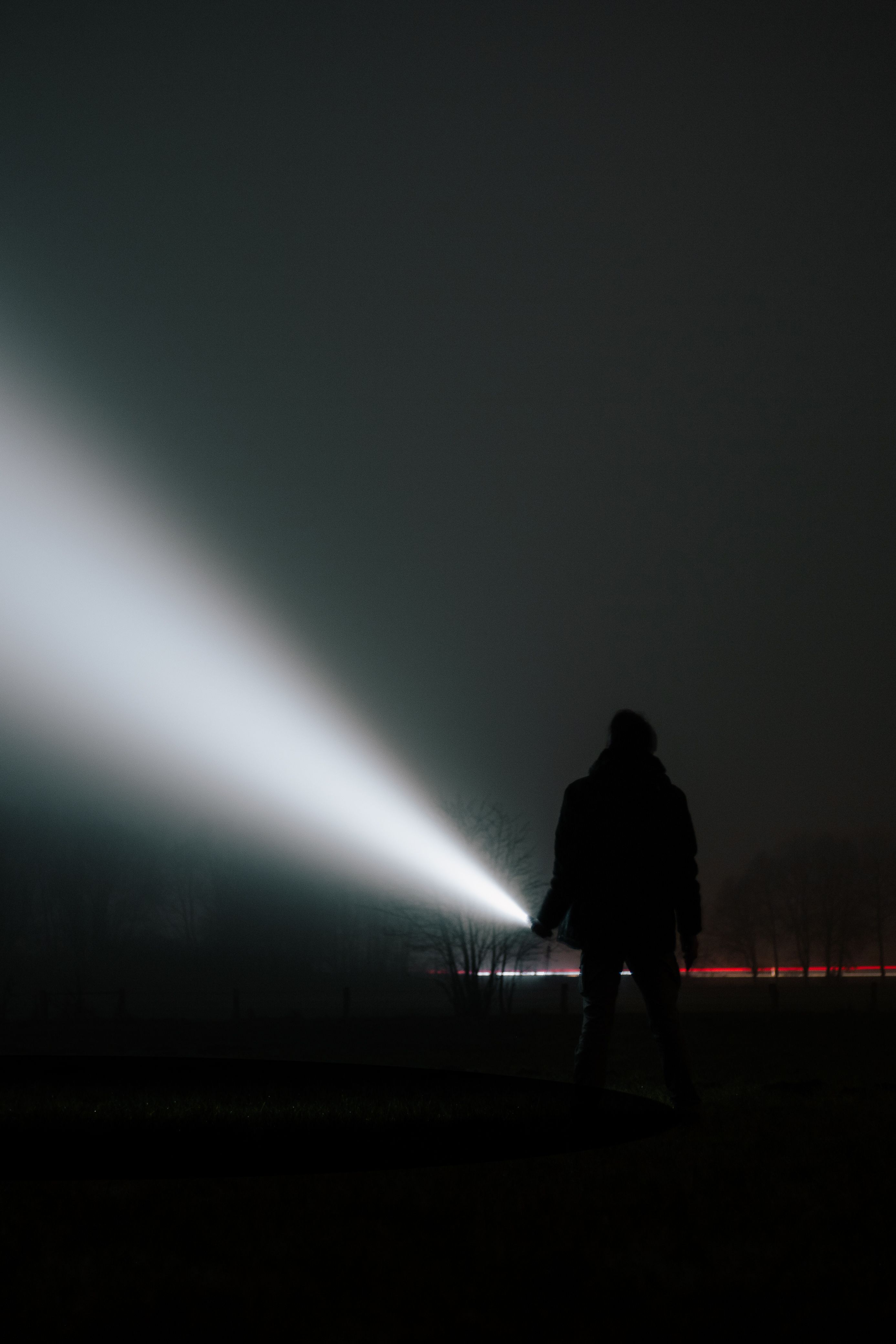 Silhouette with Flashlight in Foggy Night Scenery · Free Stock Photo