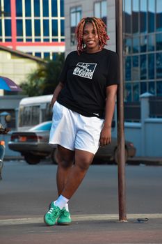 Young woman in casual attire posing confidently on a Monrovia street.
