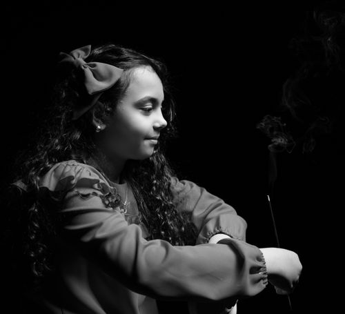 Free A thoughtful young girl in profile with smoke backdrop, black and white Stock Photo