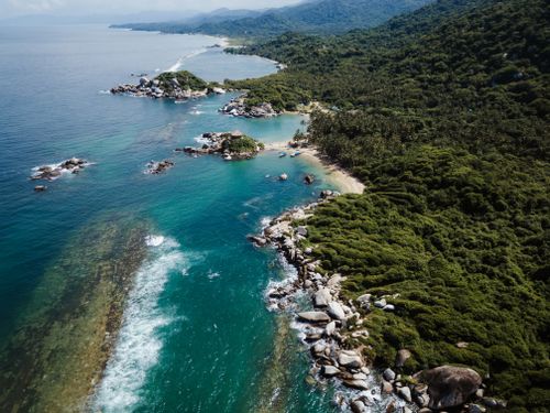 Free A breathtaking aerial view of the lush, rocky coastline in Colombia with crystal clear ocean waters. Stock Photo