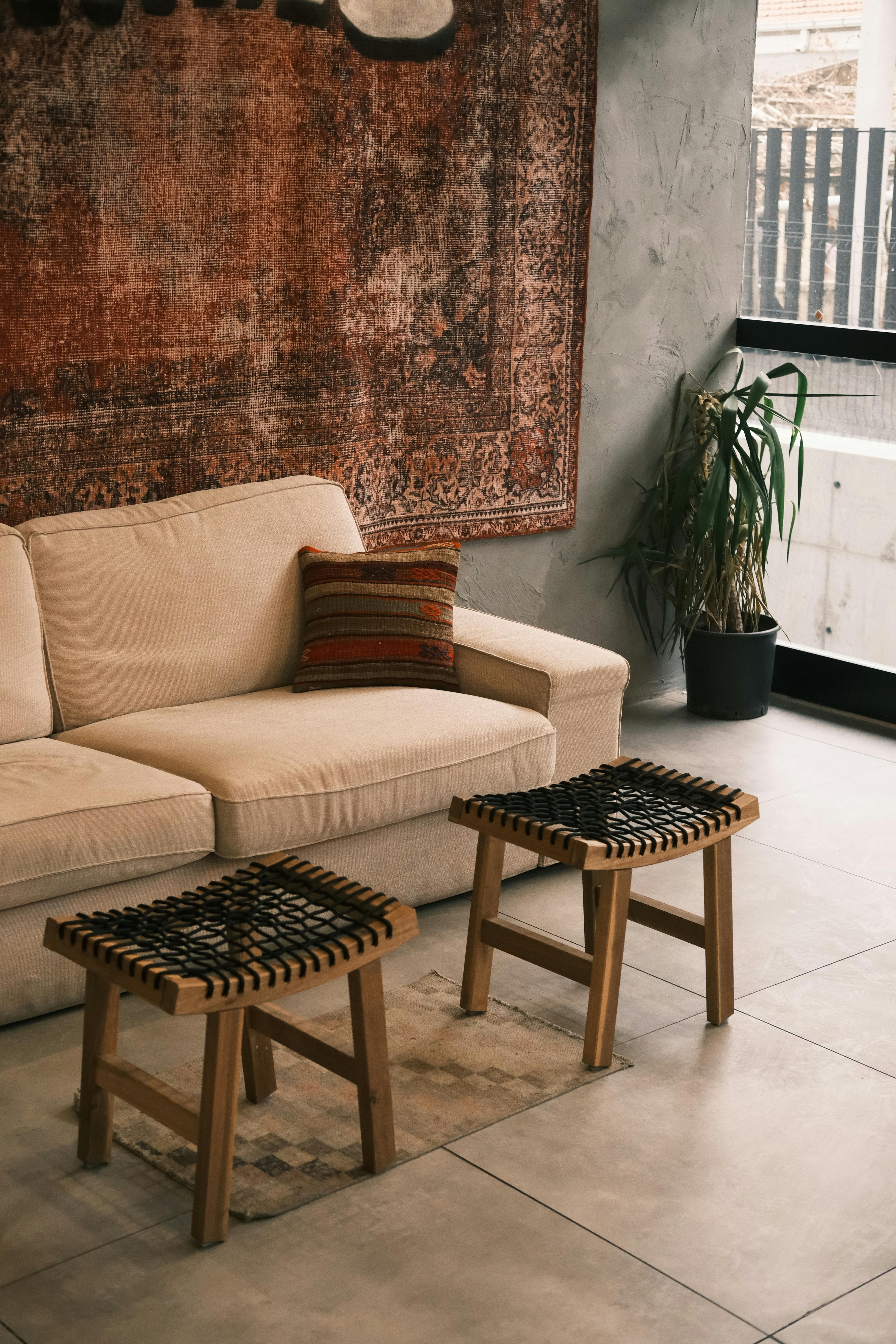 Elegant minimalist interior featuring a beige sofa and woven stools.