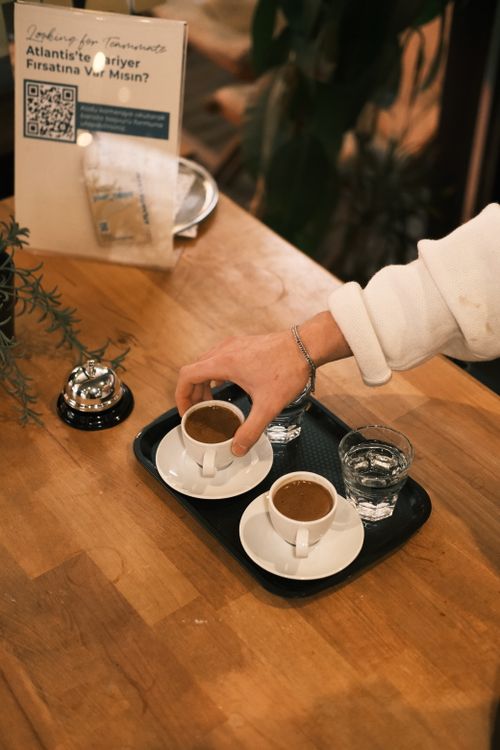 Free A warm setting depicting Turkish coffee being served on a wooden table in a cozy café. Stock Photo