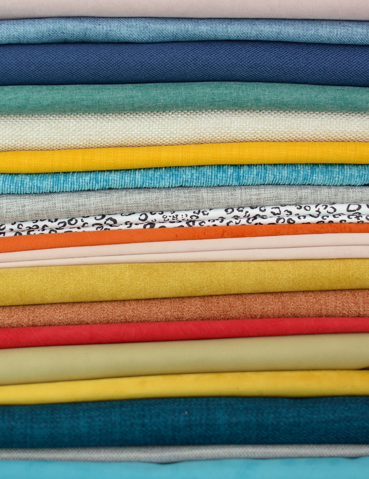 Stack of folded cotton fabrics, representing Amravati's chaddar bedsheet textile mills