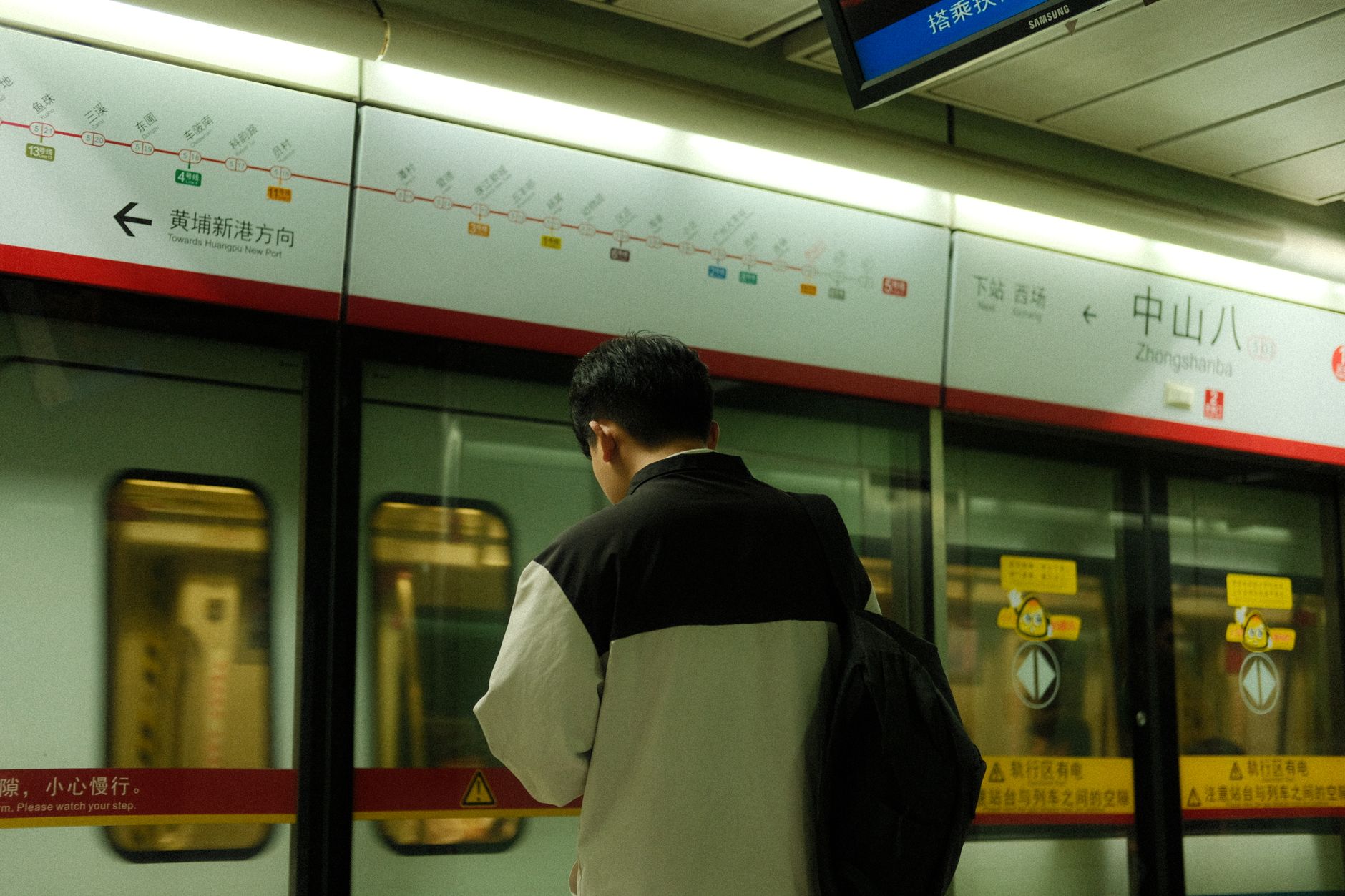 A man standing at Zhongshanba subway station, looking away.