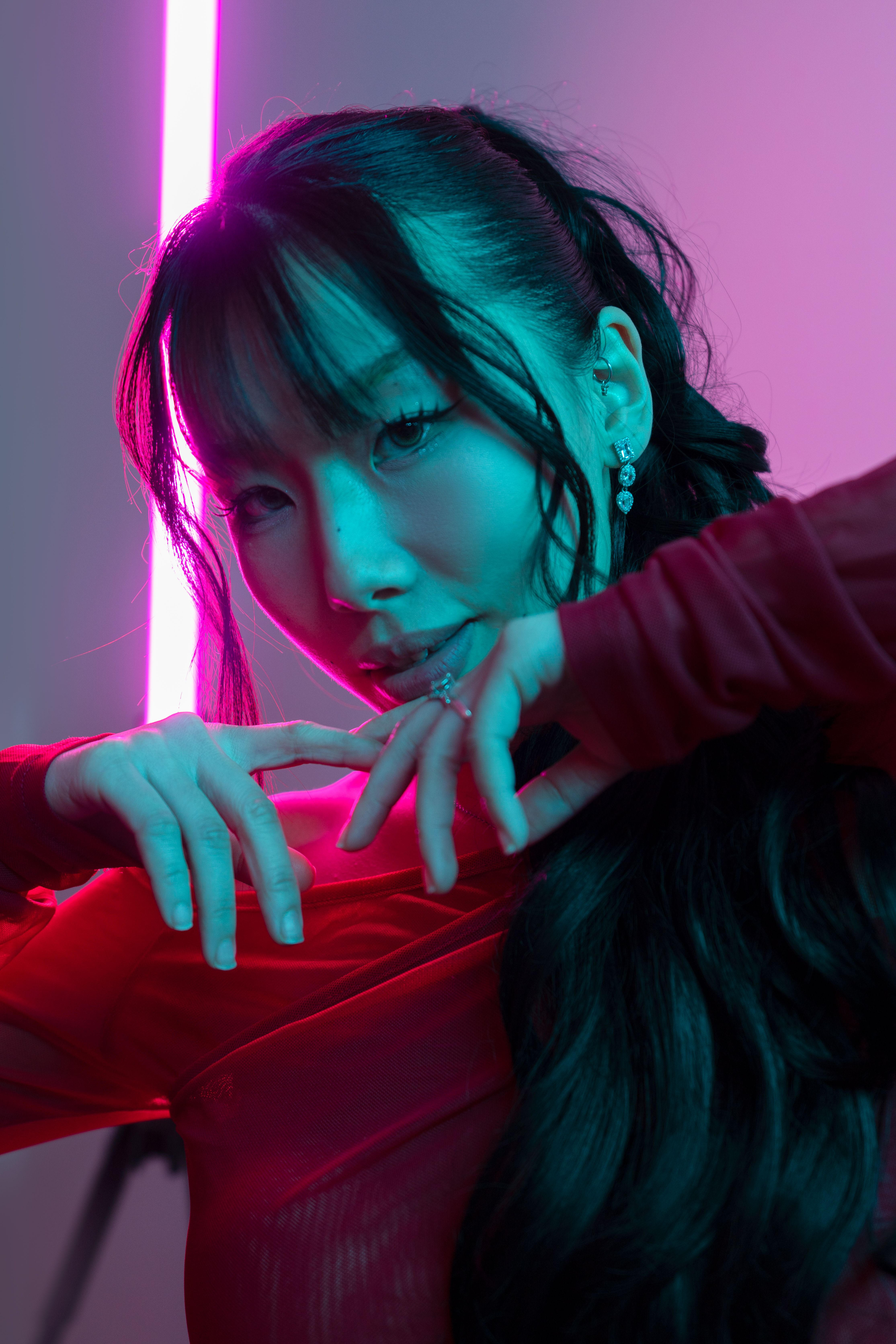 Portrait of a woman artistically posed with neon lighting, creating a vibrant and modern mood.