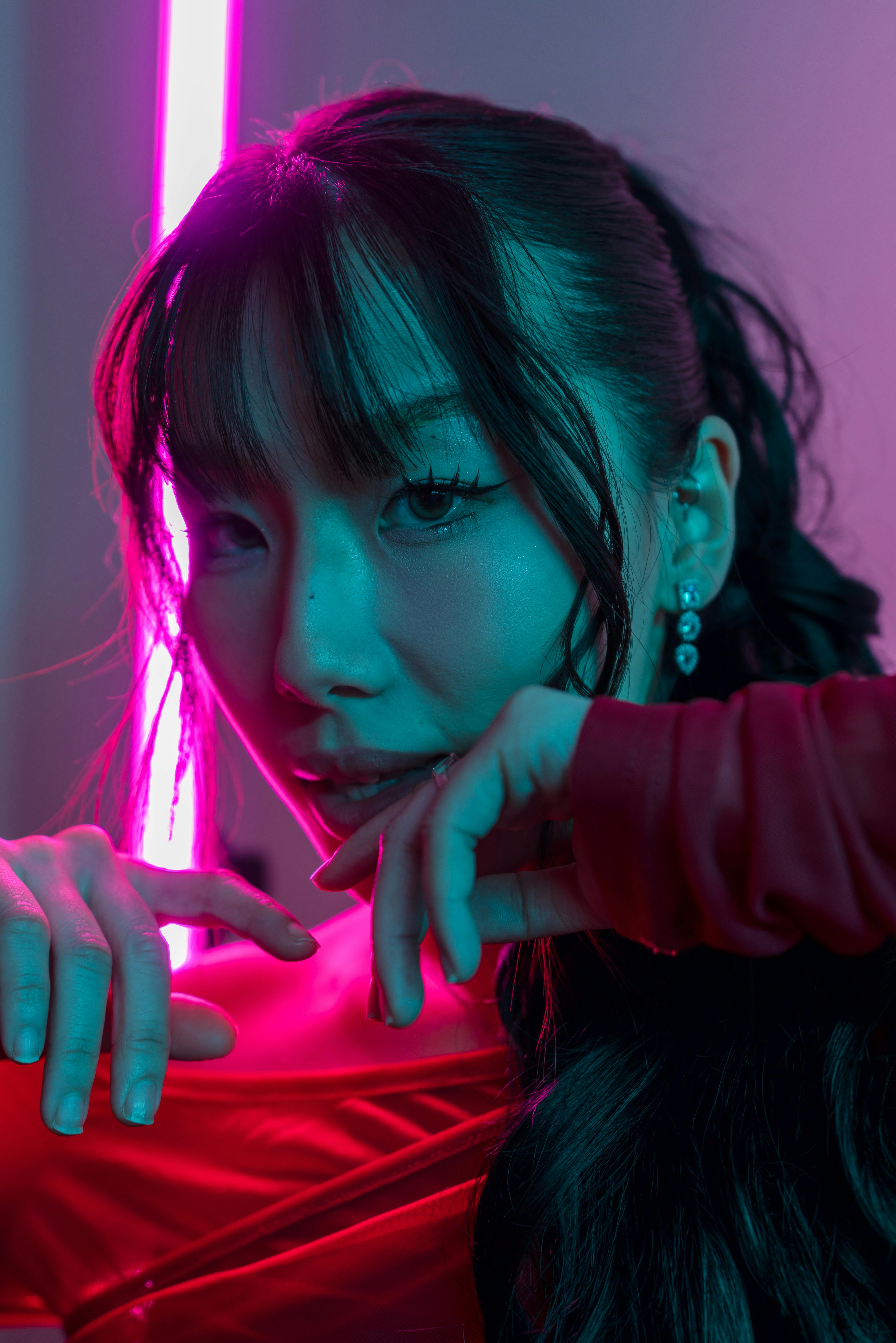 Stunning portrait of a woman illuminated by neon pink light.