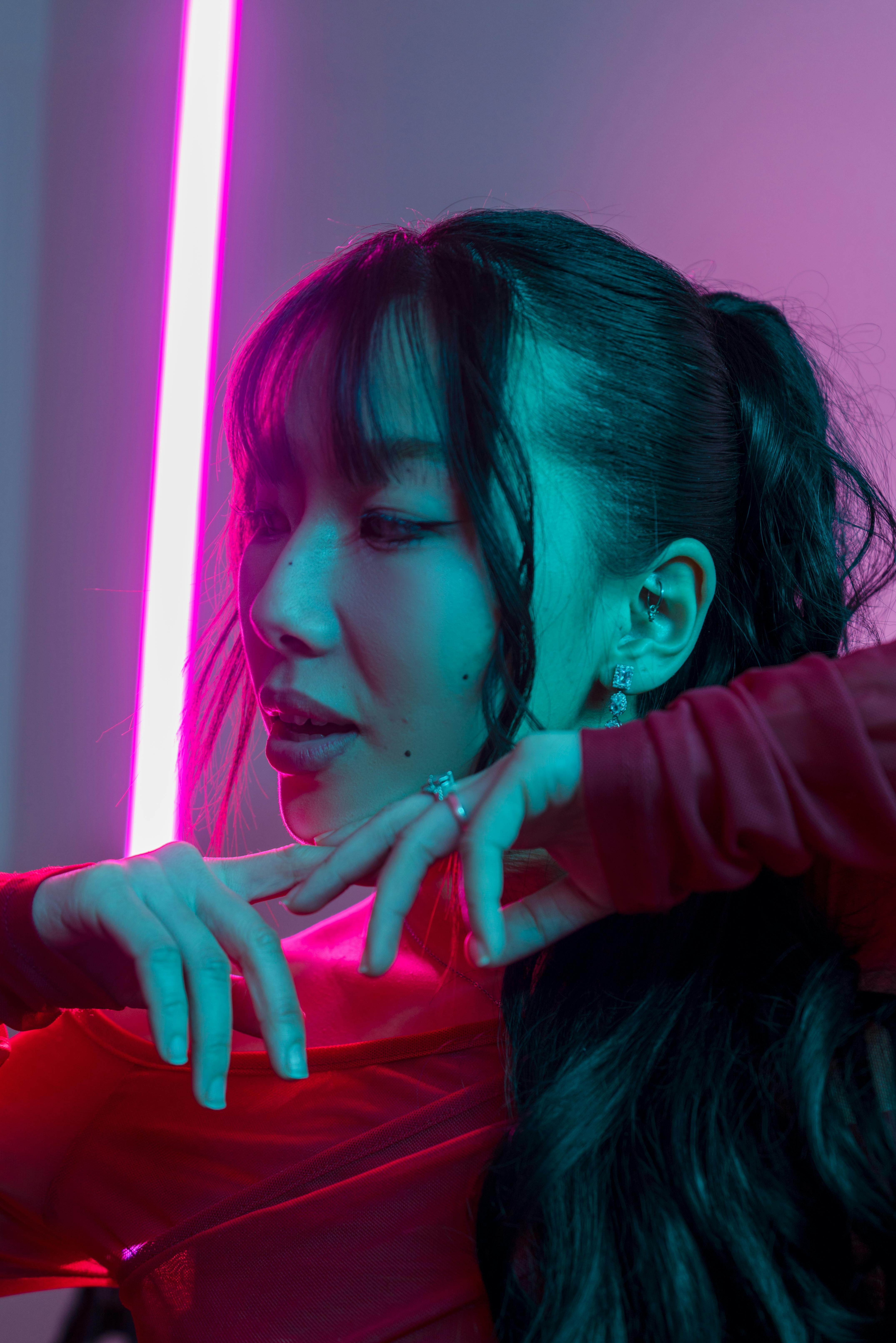 Artistic portrait featuring a woman illuminated by vibrant neon lights, capturing modern style.