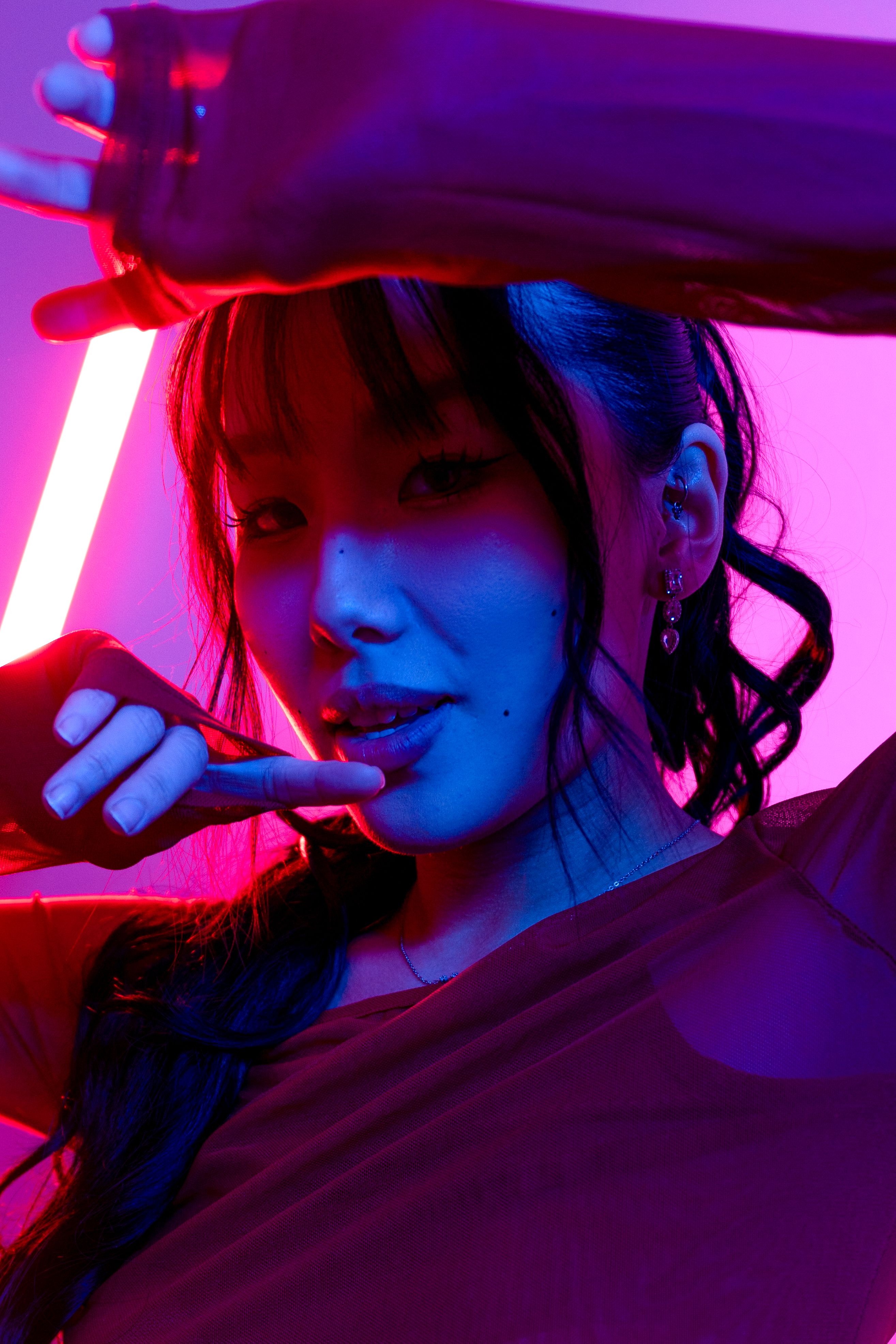 Stylish woman posing creatively with neon lights.
