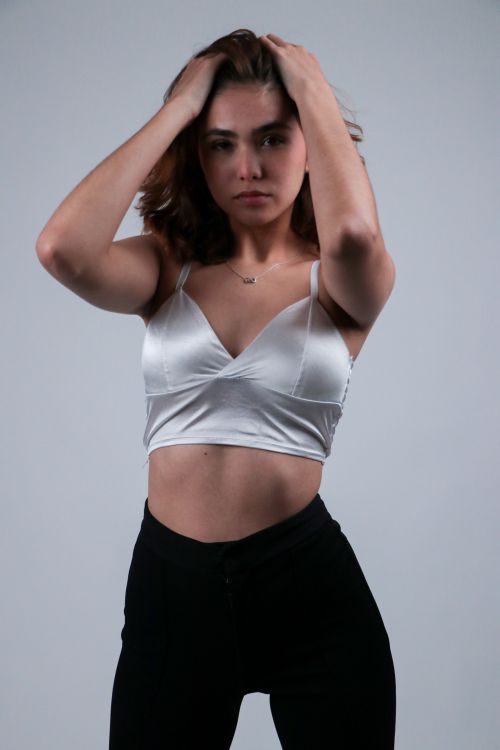 Free Stylish young woman in a white top posing confidently. Stock Photo