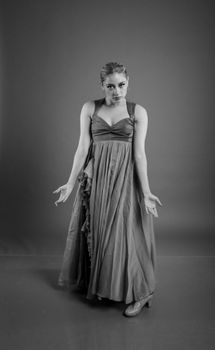 Black and white portrait of a woman in an elegant flowing gown showcasing vintage style.
