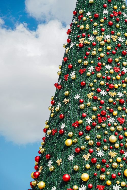 Free Decorated Christmas tree against a clear blue sky in Dubai, UAE, bringing festive cheer. Stock Photo
