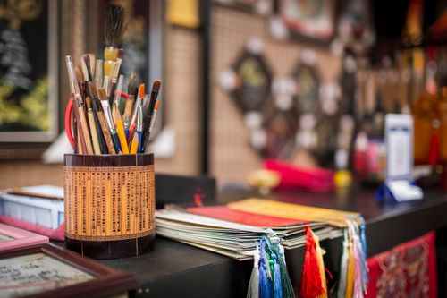 Free Traditional Vietnamese calligraphy tools set against a colorful backdrop at a crafts stall in Ho Chi Minh City. Stock Photo