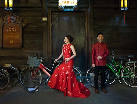 Stylish Vietnamese couple posing in traditional attire in Hoi An with vintage bicycles.
