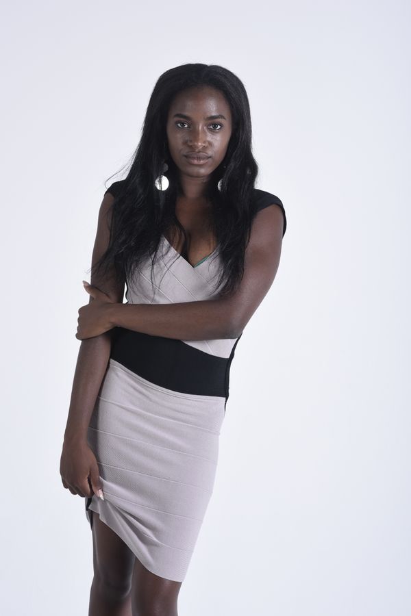 Model in a fitted two-tone dress on a studio backdrop, photo by Andrea Musto on Pexels