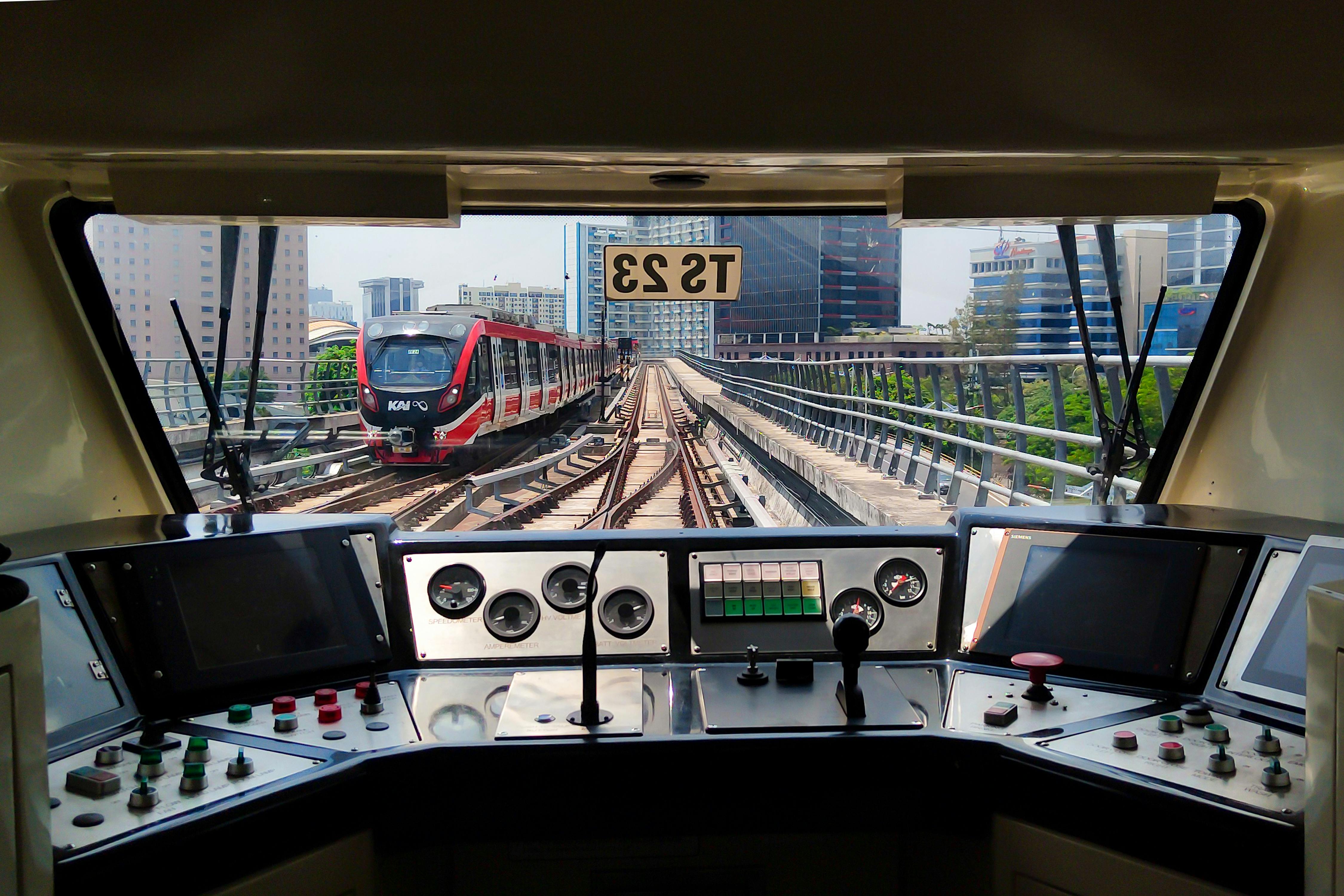 View from a train cockpit with city skyline in the background.