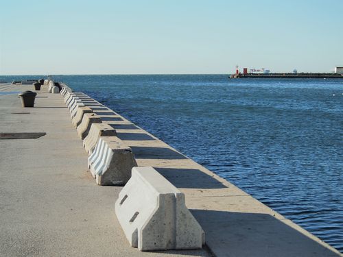 Free Trst harbor promenade overlooking the Adriatic Sea under clear skies. Stock Photo