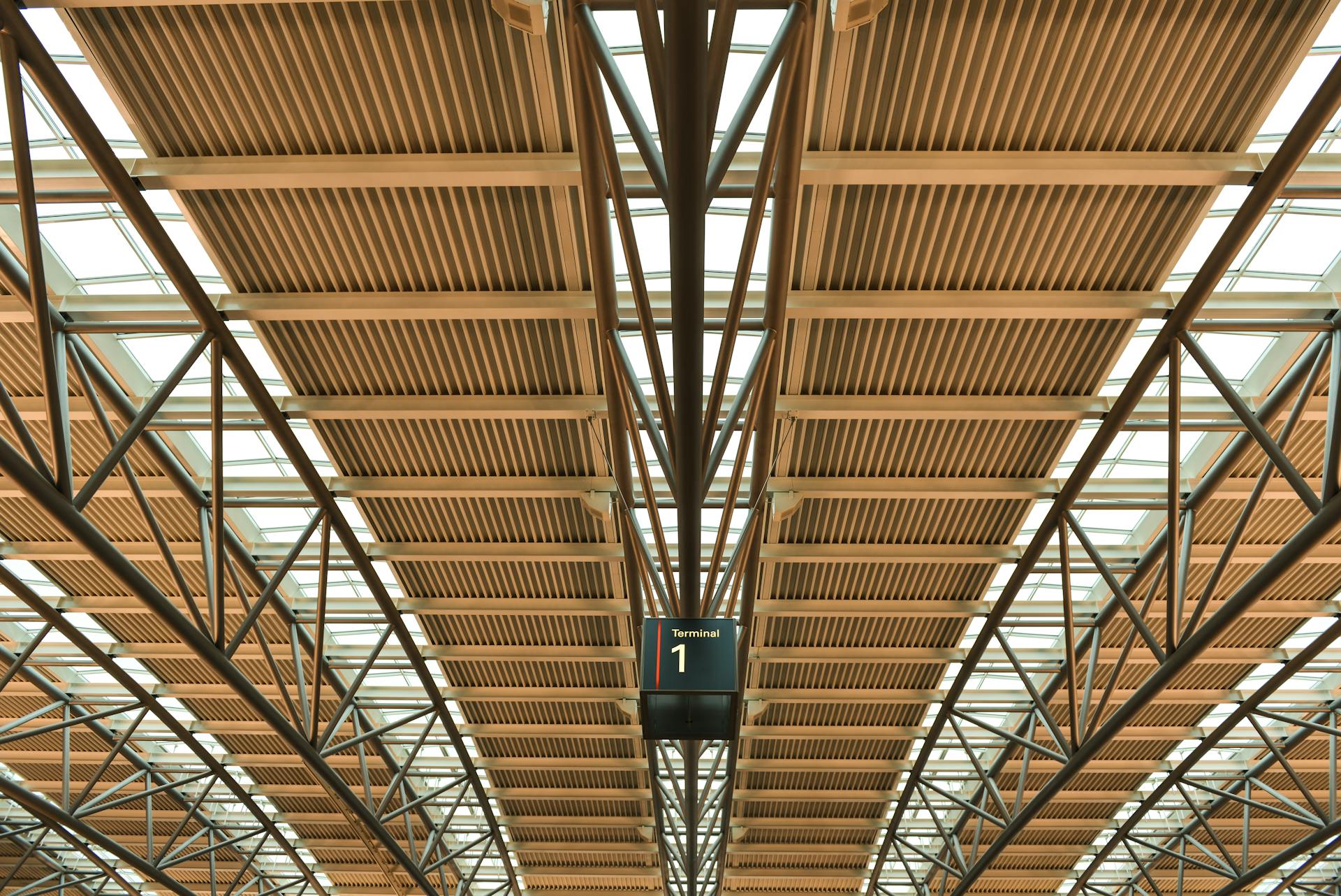 A geometric architectural ceiling view inside Terminal 1 at Hamburg Airport.