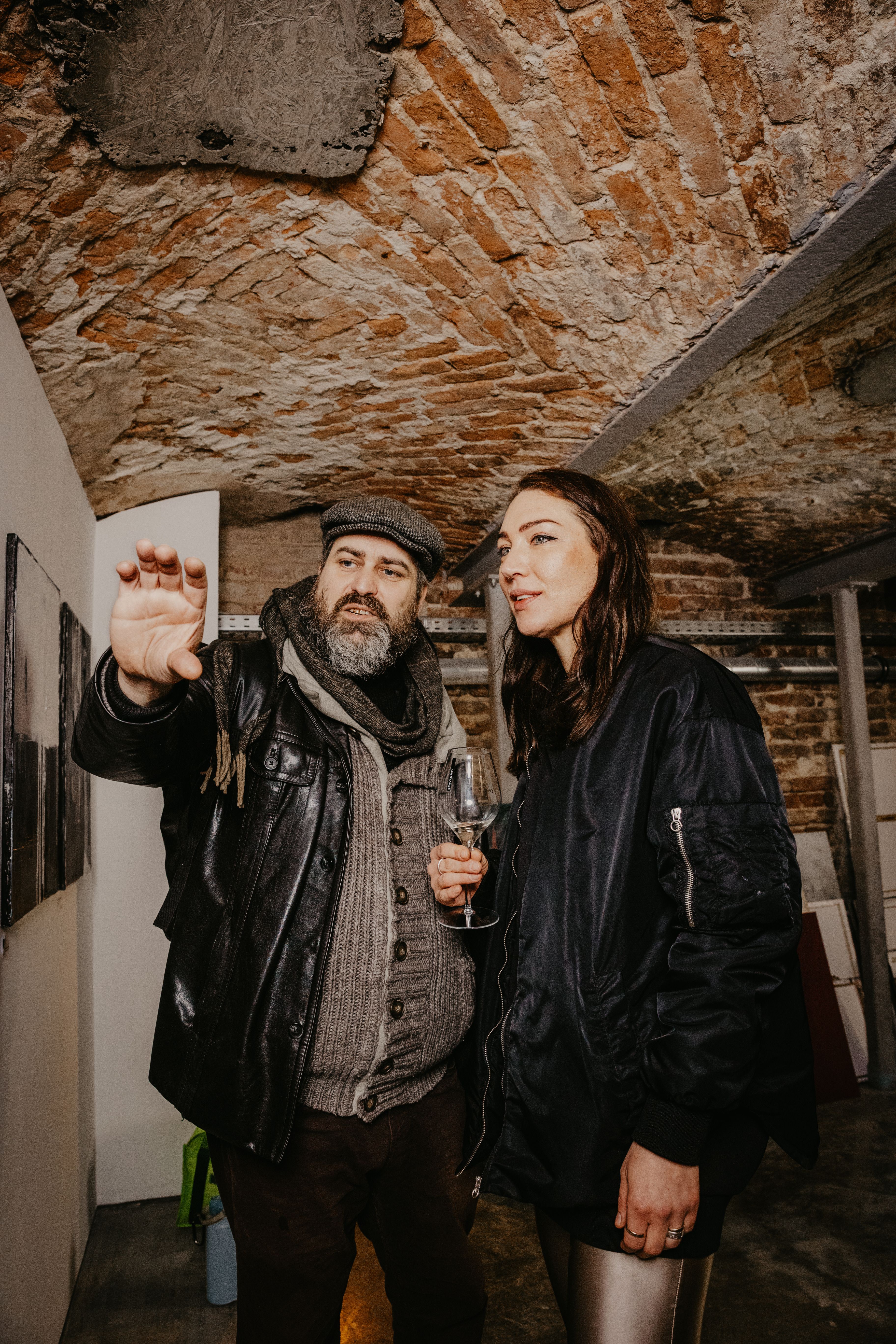 Art lovers interact at a gallery event in Berlin, showcasing vibrant discussions and cultural expression.