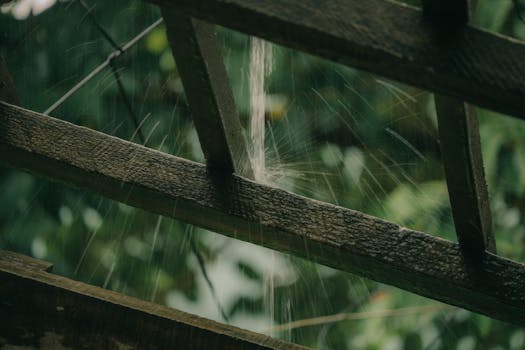 Gentle rainfall cascading through a rustic wooden structure, capturing tranquility in Quy Nhơn, Vietnam.