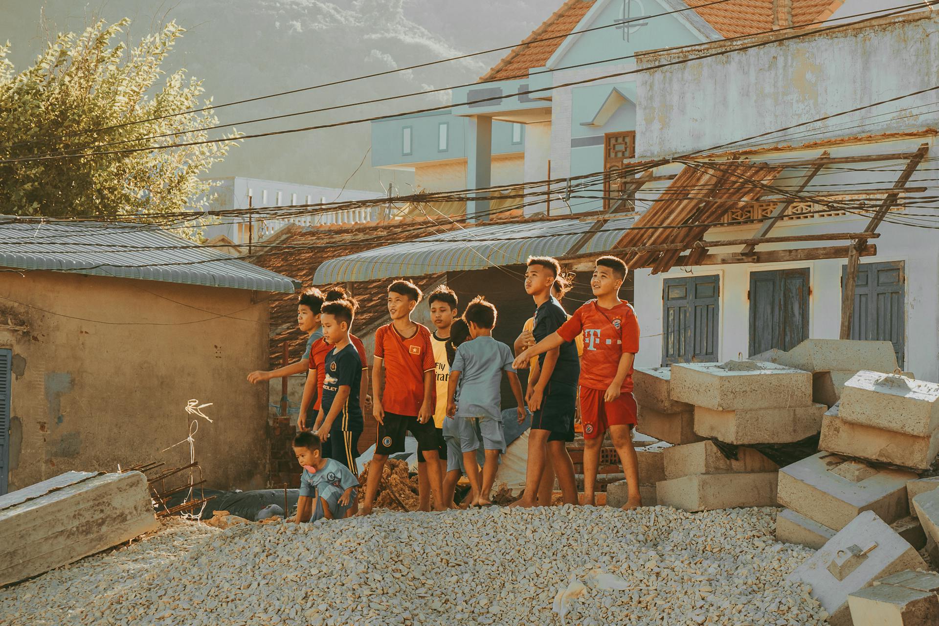 Group of boys playing around a construction site in Quy Nhơn, capturing childhood joy.